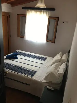 a bed in a bedroom with a window at Casa Kalliroi in Symi