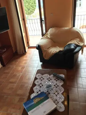 a living room with a couch and a book on a table at Casa Kalliroi in Symi