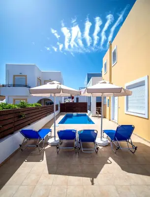 a patio with chairs and umbrellas and a pool at Gennadi Gardens Apartments & Villas in Gennadi