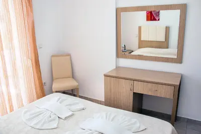 a bedroom with a bed and a mirror at Gennadi Gardens Apartments & Villas in Gennadi