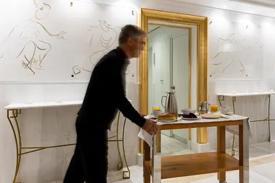 a man walking past a table in a room at Hotel Galaxias in Rhodes Town