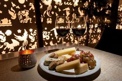 a plate of cheese and wine glasses on a table at Hotel Galaxias in Rhodes Town