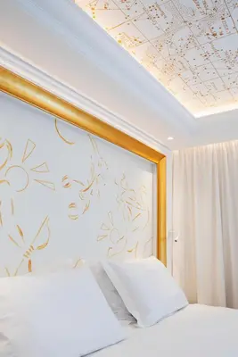 a bedroom with two beds and a ceiling with flowers at Hotel Galaxias in Rhodes Town