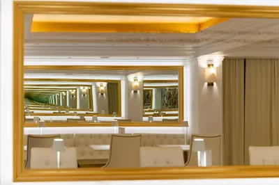 a mirror in a dining room with chairs and tables at Hotel Galaxias in Rhodes Town