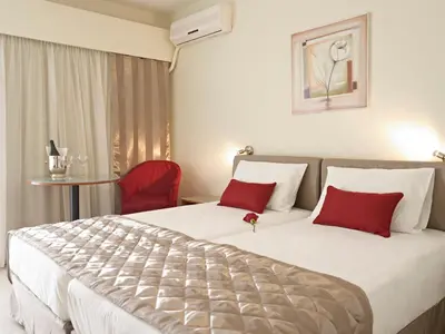 a hotel room with a large bed with red pillows at Hotel Galaxias in Rhodes Town