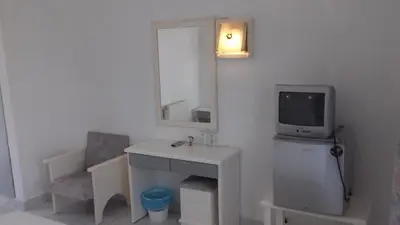 a bathroom with a sink and a tv on a wall at Amaliahotel in Apolakkiá