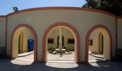 a building with arches and a fountain in a courtyard at Amaliahotel in Apolakkiá