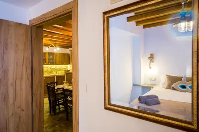 a mirror on a wall next to a bedroom at Pitropos Garden in Archangelos