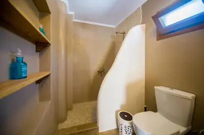 a small bathroom with a toilet and a window at Pitropos Garden in Archangelos