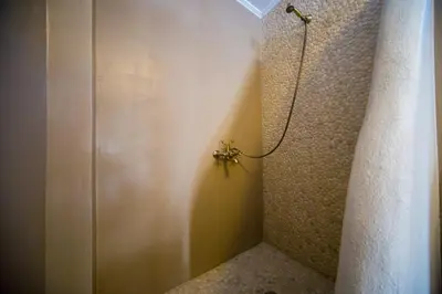 a bathroom with a spider on the corner of a shower at Pitropos Garden in Archangelos