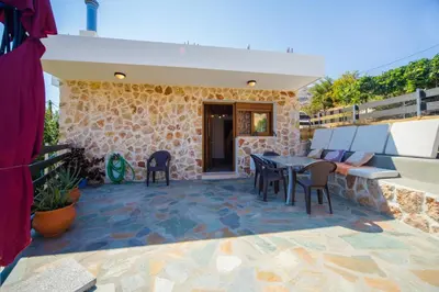 a patio of a house with a table and chairs at Pitropos Garden in Archangelos