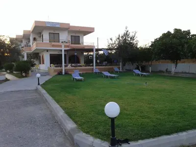 a house with a lawn with benches in front of it at Vera Studios in Faliraki