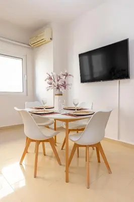 a dining room with a table and chairs and a tv at Central Luxurious Apartments Close to the Sea in Rhodes Town