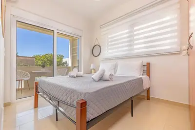 a bedroom with a bed and a large window at Central Luxurious Apartments Close to the Sea in Rhodes Town
