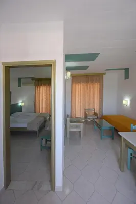 a room with a bed and a couch and a table at Trianta Hotel Apartments in Ialyssos