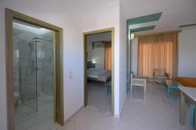 a bathroom with a shower and a room with a bedroom at Trianta Hotel Apartments in Ialyssos