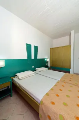 a bedroom with a large bed with green walls at Trianta Hotel Apartments in Ialyssos