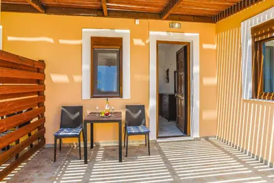 a patio with a table and two chairs and a door at Villa Ophelia in Líndos