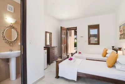 a bedroom with a bed and a sink and a mirror at Villa Ophelia in Líndos