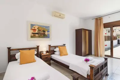 a bedroom with two beds and a window at Villa Ophelia in Líndos