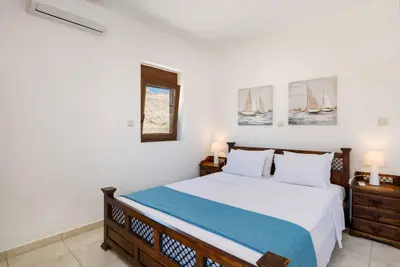 a bedroom with a bed with two night stands and two lamps at Villa Ophelia in Líndos