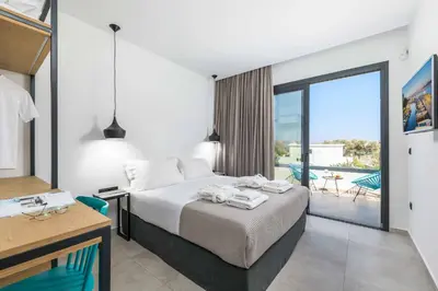 a hotel room with a bed and a balcony at Lambis Harmonia in Líndos