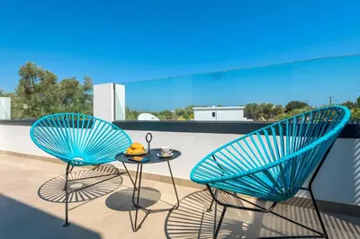 two blue chairs and a table on a balcony at Lambis Harmonia in Líndos