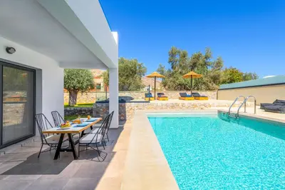 a patio with a table and a swimming pool at Lambis Harmonia in Líndos