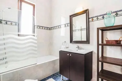 a bathroom with a sink and a tub and a mirror at Villa Ioanna in Líndos