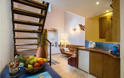 a kitchen with a bowl of fruit on a table at Lindos Boutique - Adults Only in Líndos
