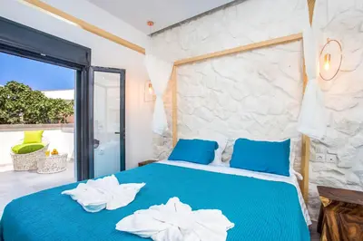 a bedroom with a blue bed with towels on it at Papenas Cozy Home in Faliraki