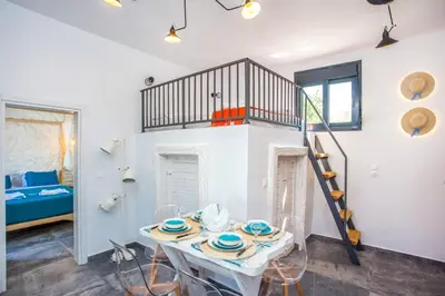a room with a table and a spiral staircase at Papenas Cozy Home in Faliraki