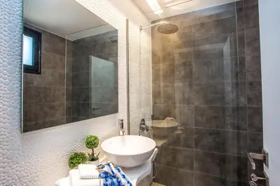 a bathroom with a sink and a shower and a toilet at Papenas Cozy Home in Faliraki