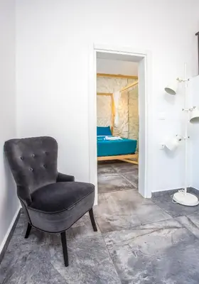 a black chair in a room with a bedroom at Papenas Cozy Home in Faliraki