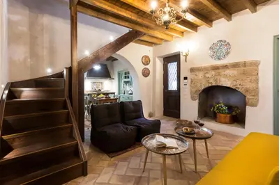 a living room with a staircase and a fireplace at Tafros Villa in Rhodes Town