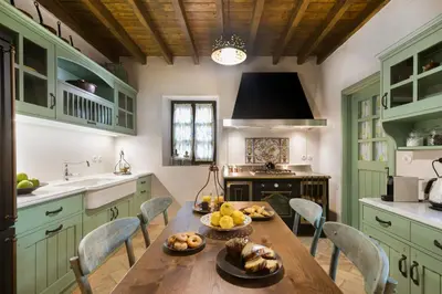 a kitchen with green cabinets and a table with food on it at Tafros Villa in Rhodes Town