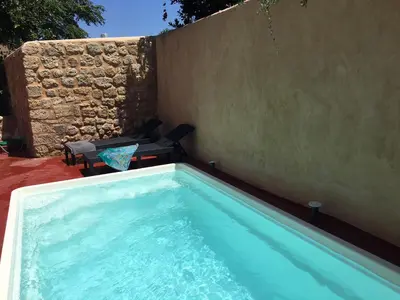 a swimming pool in front of a wall at Tafros Villa in Rhodes Town