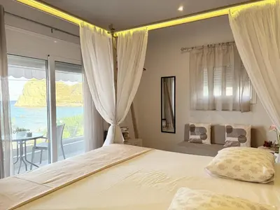 a bedroom with a bed and a view of the ocean at M&N Apartments in Archangelos