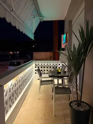 a table and chairs on a balcony at night at M&N Apartments in Archangelos