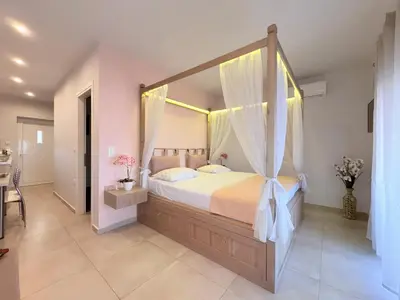 a large bedroom with a canopy bed with curtains at M&N Apartments in Archangelos
