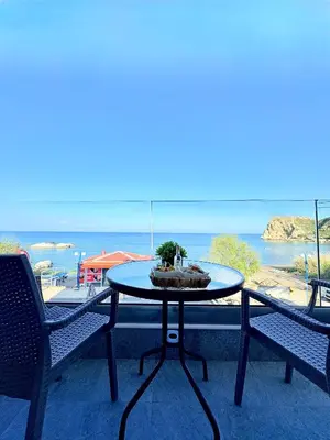 a table on a balcony with a view of the ocean at M&N Apartments in Archangelos