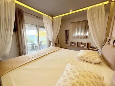 a bedroom with a large bed with a large window at M&N Apartments in Archangelos
