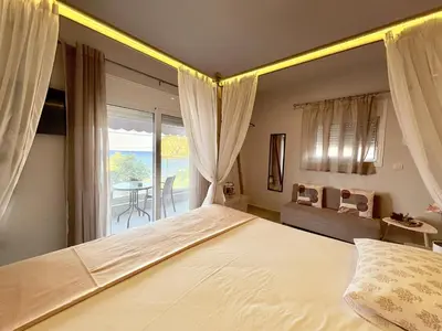 a bedroom with a large bed and a balcony at M&N Apartments in Archangelos