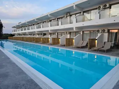 a hotel swimming pool with chairs and a building at BELVITA Hotel in Kolimbia