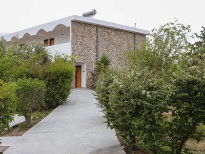 a walkway leading to a building with bushes at BELVITA Hotel in Kolimbia
