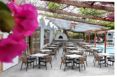 a row of tables and chairs on a patio at BELVITA Hotel in Kolimbia