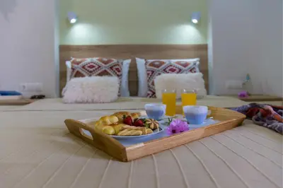 a tray with a plate of fruit on a bed at Haraki Blue Pearl in Haraki