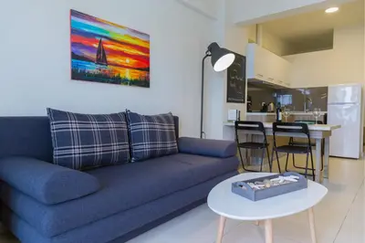 a living room with a blue couch and a table at Haraki Blue Pearl in Haraki