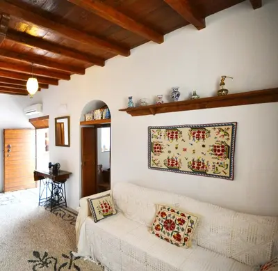 a living room with a white couch and a painting on the wall at Casa Lindos in Líndos