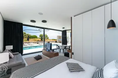 a bedroom with a bed and a living room at amara luxury villas in Lachania